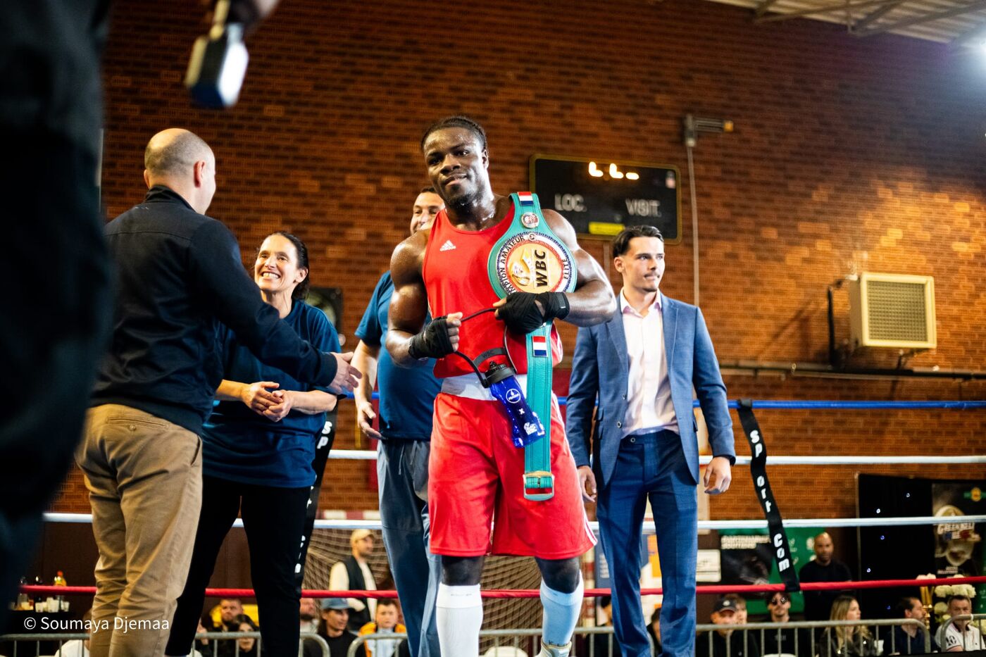 Un boxeur du club entrant sur le ring avec sa ceinture de champion
