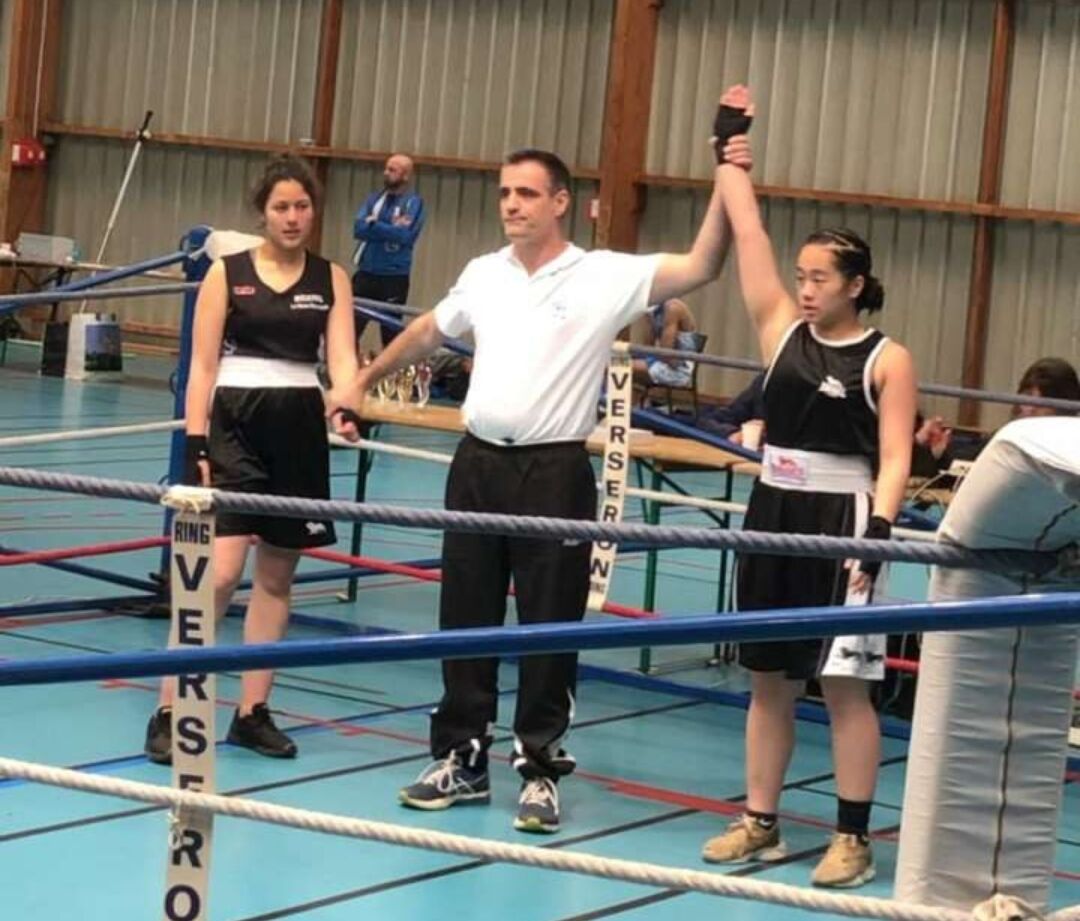 L'arbitre lève le bras d'une boxeuse victorieuse
